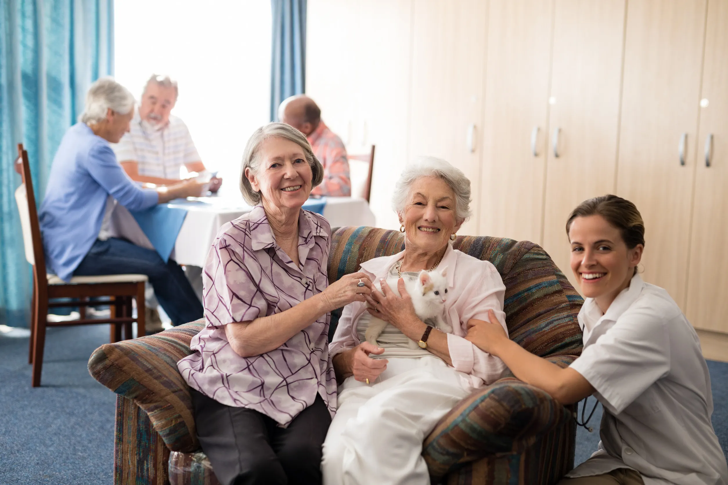 Portrait of female practitioner with kitten at nursing home